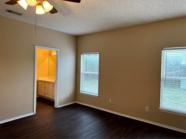 unfurnished bedroom with dark wood-style floors, visible vents, ceiling fan, a textured ceiling, and baseboards