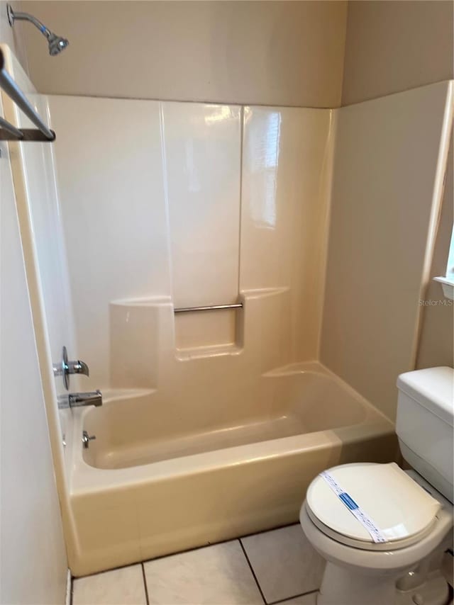 bathroom with toilet, tile patterned flooring, and washtub / shower combination