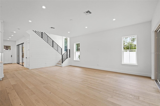 unfurnished living room with light wood finished floors, stairway, visible vents, and recessed lighting