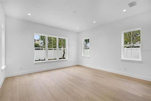 unfurnished room featuring light wood-style floors, baseboards, visible vents, and recessed lighting