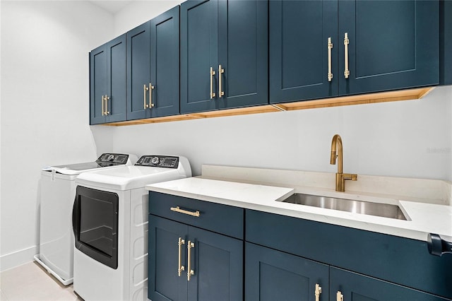 laundry area featuring washing machine and clothes dryer, cabinet space, light tile patterned flooring, a sink, and baseboards