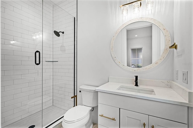 bathroom featuring a stall shower, vanity, and toilet