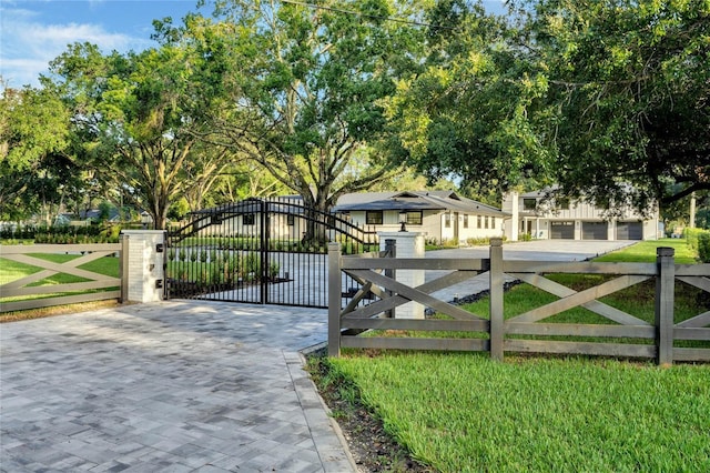 view of gate with a fenced front yard and a lawn