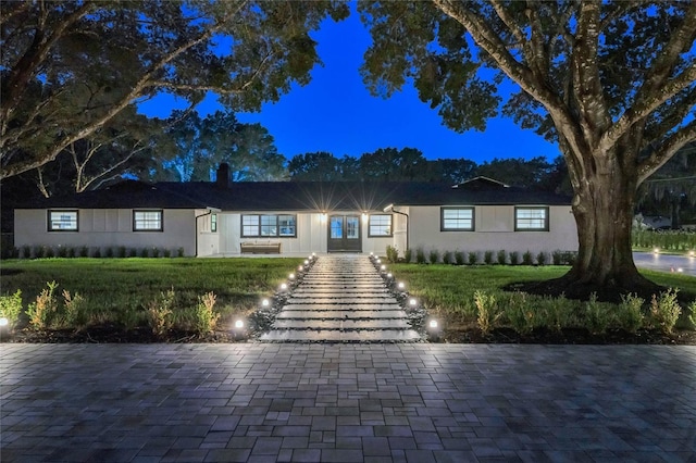 ranch-style home with a lawn and a chimney