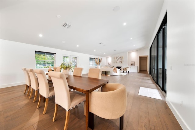 dining space with vaulted ceiling, recessed lighting, visible vents, and light wood-style floors