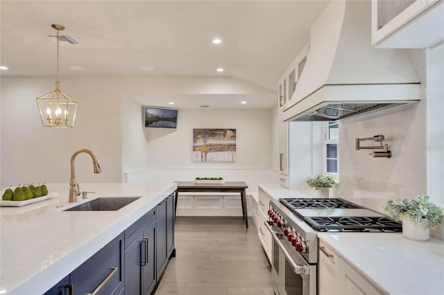 kitchen with glass insert cabinets, custom exhaust hood, double oven range, white cabinetry, and a sink