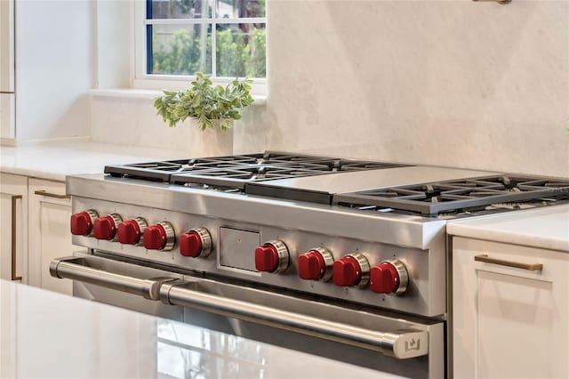 room details featuring range with two ovens, light countertops, and white cabinetry