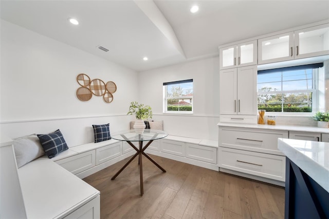 interior space with visible vents, breakfast area, wood finished floors, vaulted ceiling, and recessed lighting