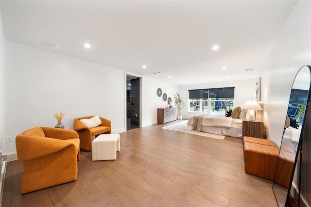 bedroom with light wood-style floors, baseboards, and recessed lighting