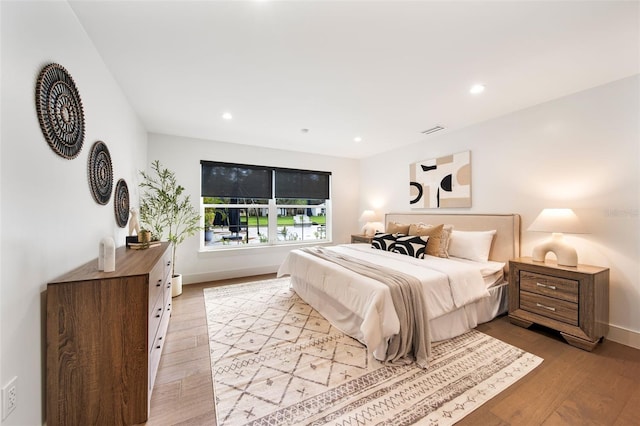 bedroom with light wood-type flooring, visible vents, baseboards, and recessed lighting