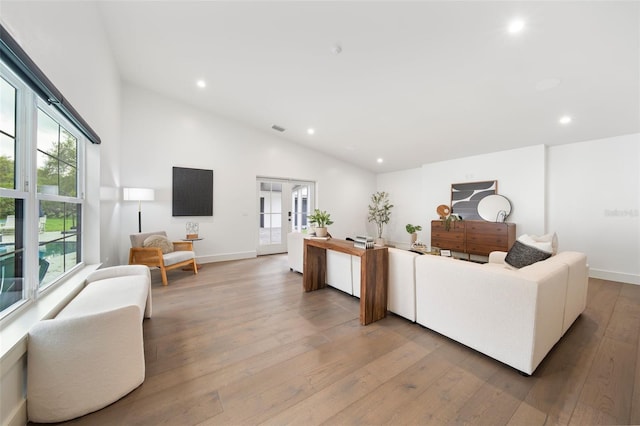 living area featuring light wood-type flooring, recessed lighting, baseboards, and french doors