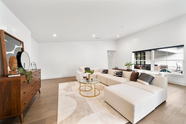 living area with light wood-style floors, recessed lighting, vaulted ceiling, and baseboards