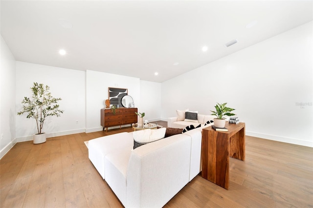 living room with light wood finished floors, recessed lighting, visible vents, and baseboards