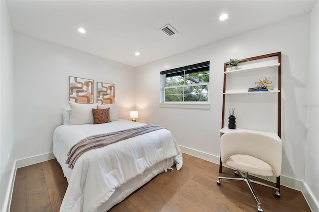 bedroom with baseboards, visible vents, wood finished floors, and recessed lighting