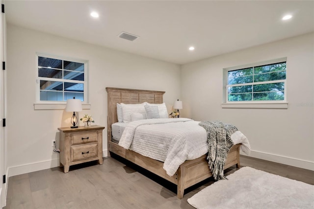 bedroom featuring light wood finished floors, recessed lighting, visible vents, and baseboards