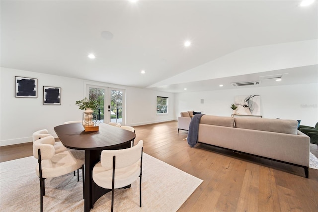 dining room featuring light wood-type flooring, baseboards, vaulted ceiling, and french doors