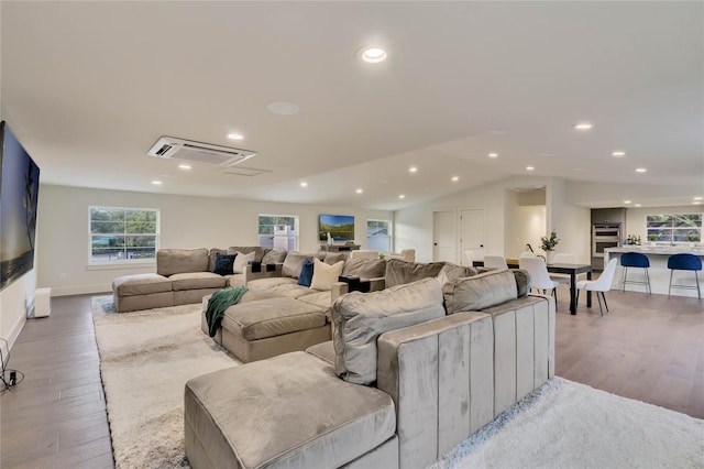 living area featuring light wood-type flooring, recessed lighting, baseboards, and lofted ceiling