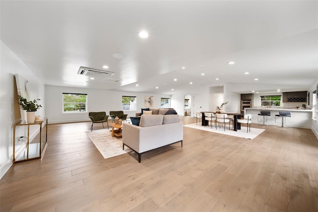 living area with vaulted ceiling, recessed lighting, and light wood-style floors