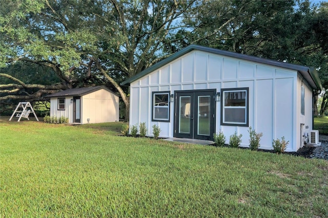 exterior space featuring a front yard, board and batten siding, and an outbuilding