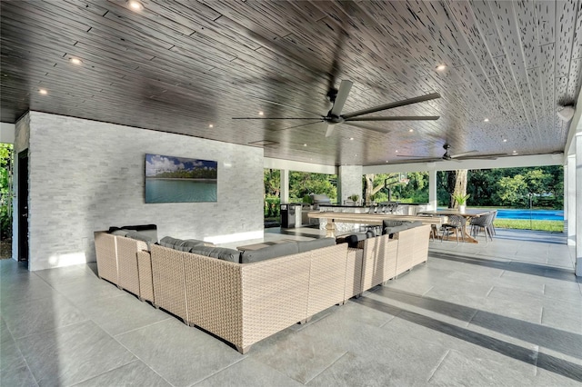 view of patio with an outdoor kitchen, an outdoor hangout area, and a ceiling fan