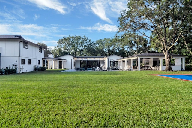 back of property featuring a patio area and a lawn