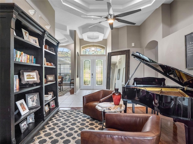 living area with a ceiling fan, french doors, and light tile patterned floors