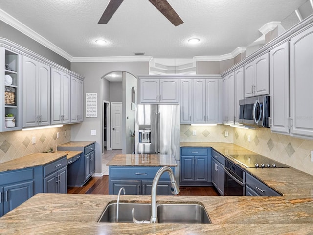 kitchen featuring open shelves, stainless steel appliances, a sink, ceiling fan, and blue cabinets