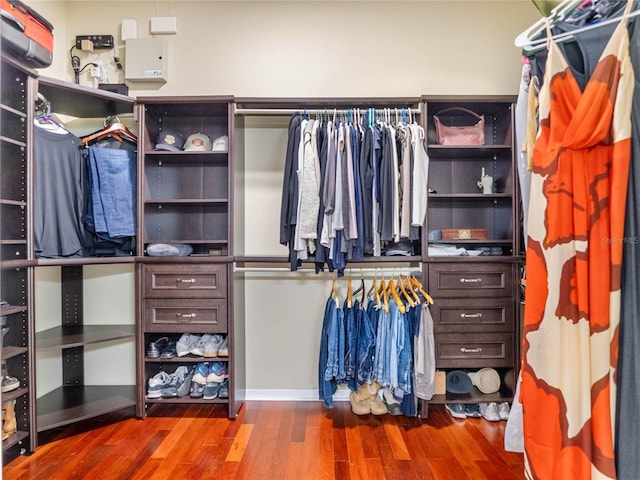 walk in closet with wood finished floors