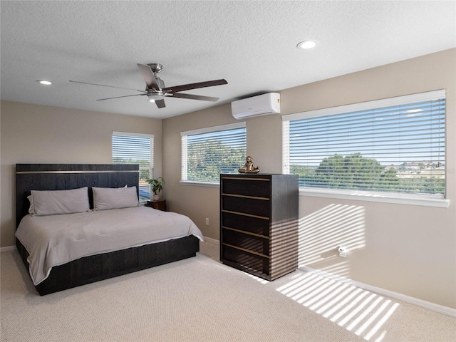 carpeted bedroom featuring a ceiling fan, baseboards, a textured ceiling, and a wall mounted AC