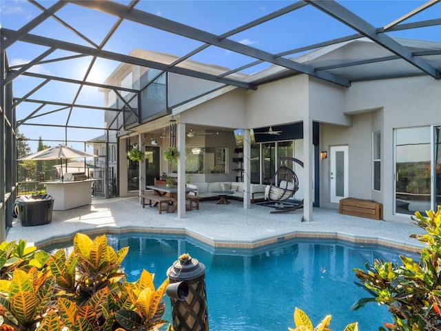 pool with glass enclosure, outdoor lounge area, and a patio