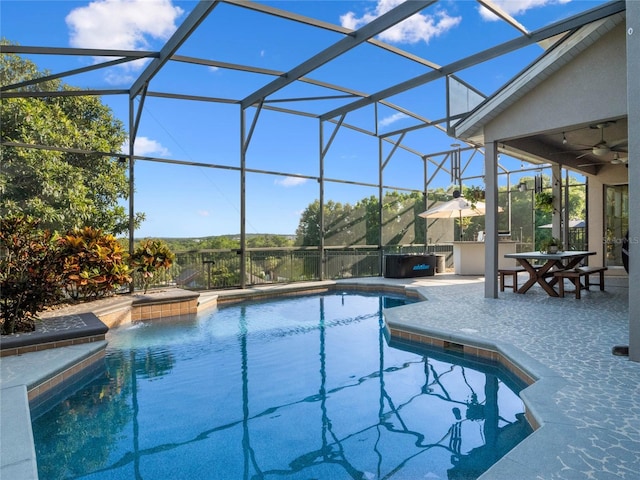 outdoor pool with a lanai, a patio area, and ceiling fan