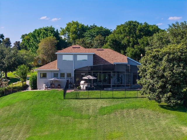 back of property featuring stucco siding, a lawn, a patio area, glass enclosure, and fence