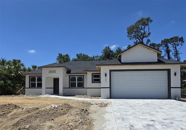 2607 Seagull Ln, North Port, FL 34286 - view of front of house with stucco siding, a garage, decorative driveway, and roof with shingles