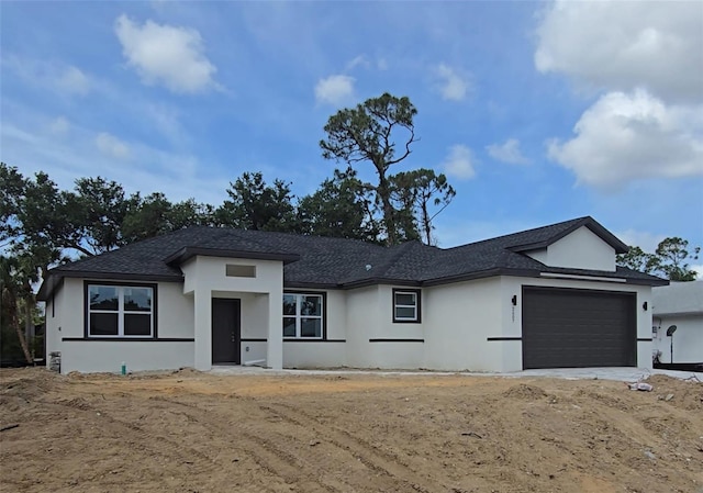 2607 Seagull Ln, North Port, FL 34286 - prairie-style home featuring stucco siding, an attached garage, and roof with shingles