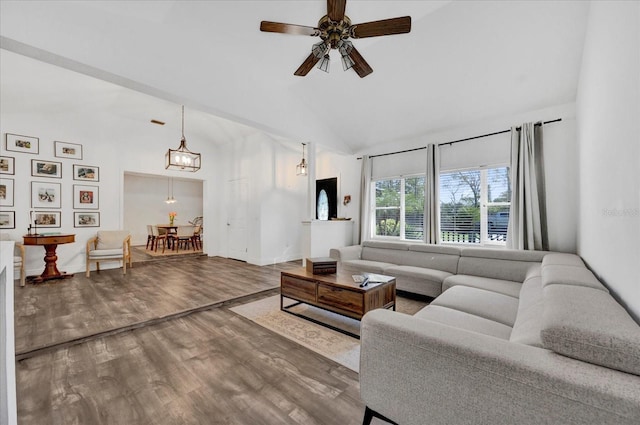 living room featuring high vaulted ceiling, ceiling fan, baseboards, and wood finished floors