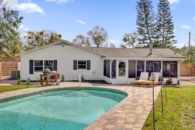 rear view of house with a fenced in pool, a sunroom, a patio, and fence