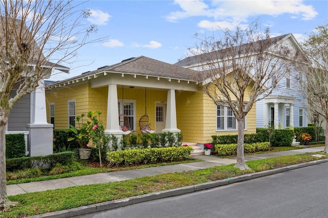 view of front of home featuring covered porch and roof with shingles