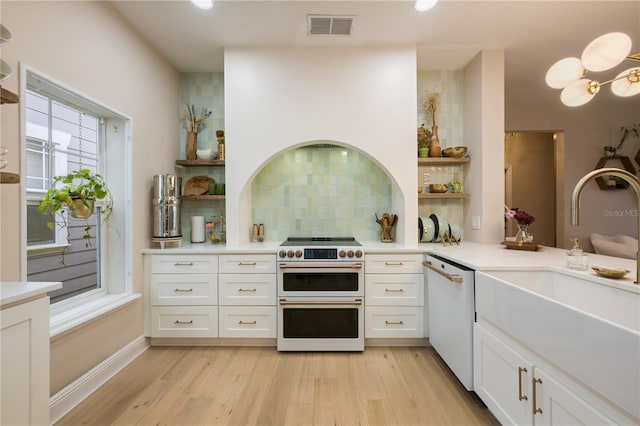 kitchen with range with two ovens, visible vents, light countertops, dishwasher, and open shelves