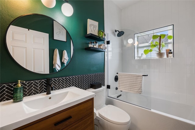 full bath featuring decorative backsplash, vanity, toilet, and bath / shower combo with glass door