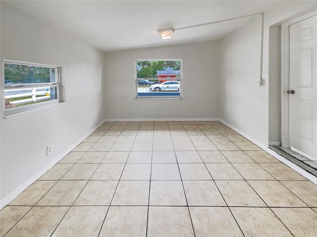 unfurnished room with plenty of natural light and baseboards