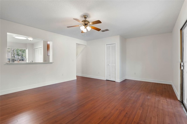 unfurnished room with visible vents, ceiling fan, a textured ceiling, baseboards, and hardwood / wood-style flooring