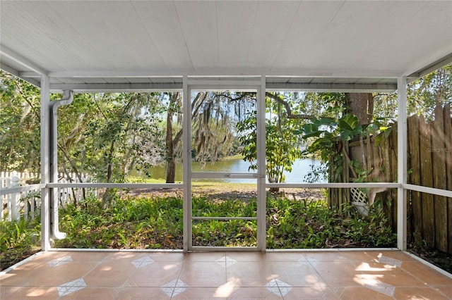 unfurnished sunroom featuring a water view