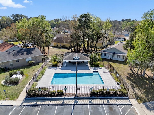 pool with a residential view, fence, cooling unit, and a patio