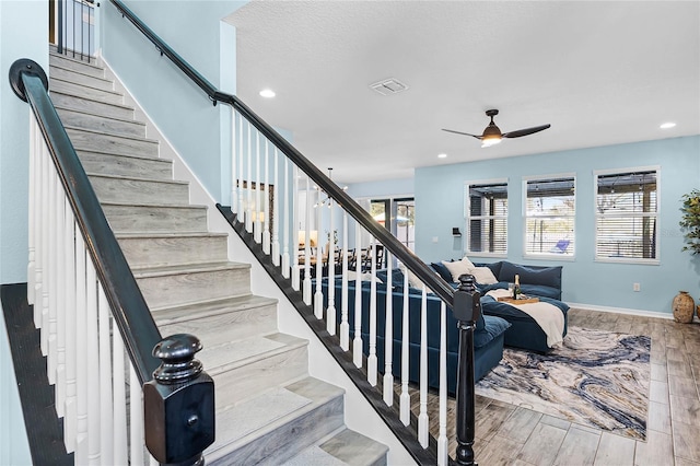 stairs with a ceiling fan, recessed lighting, baseboards, and wood finished floors