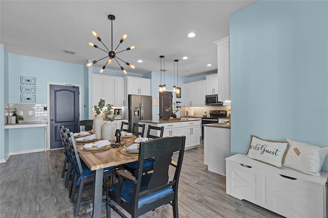 dining room with recessed lighting, a notable chandelier, and wood finished floors