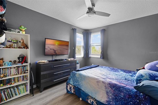 bedroom featuring a textured ceiling, a ceiling fan, and wood finished floors