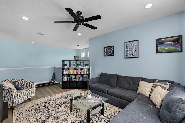 living area featuring a textured ceiling, wood finished floors, visible vents, and recessed lighting