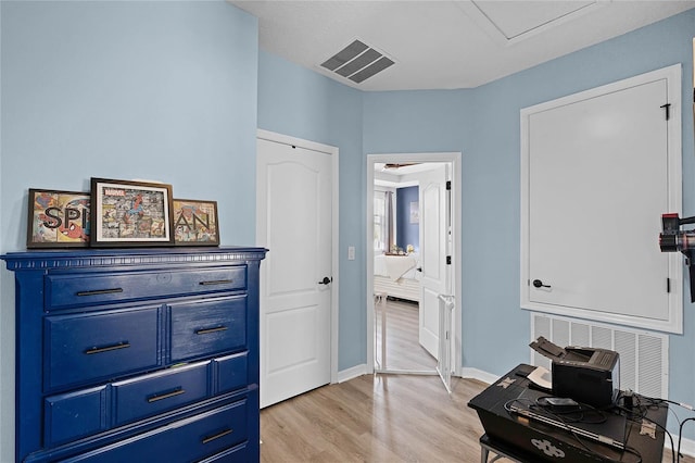 interior space with light wood finished floors, visible vents, and baseboards