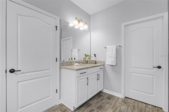 bathroom with vanity, baseboards, and wood finished floors