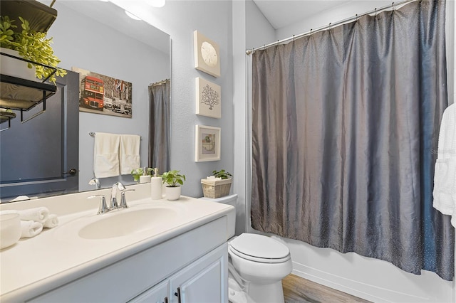 bathroom featuring toilet, shower / bath combination with curtain, wood finished floors, and vanity